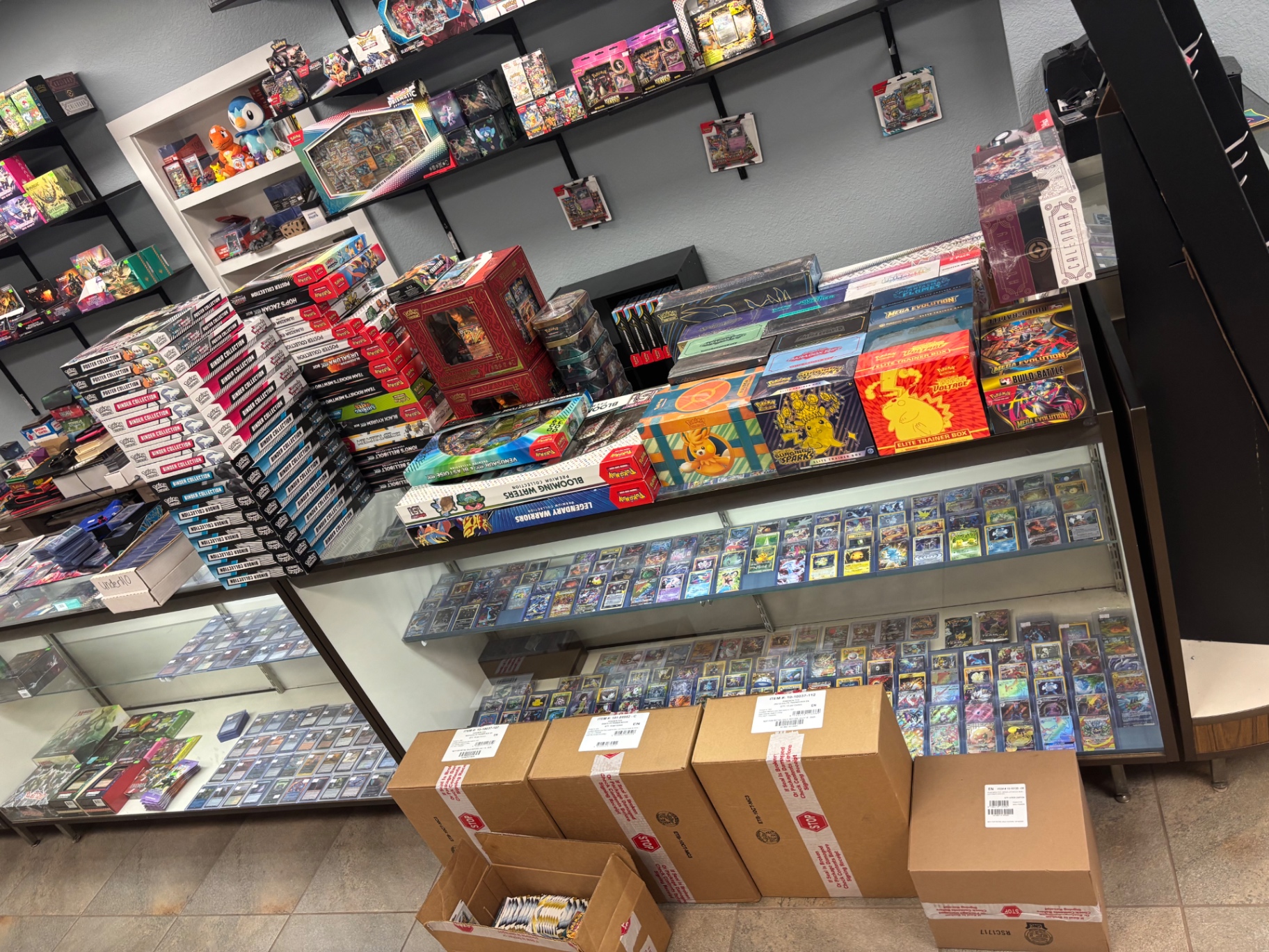 Pokémon sealed product wall, binder collection stacks, and singles cases inside Heavy Cards